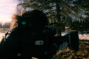 Suzan Noesen holding an Arri SR1 camera outside in front of a tree